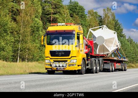 Le camion-grue jaune K. Jousmaa transporte un objet industriel sur une remorque un après-midi ensoleillé. Route 25, Raasepori, Finlande. 9 septembre 2021. Banque D'Images