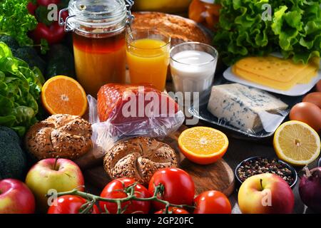 Assortiment de produits biologiques sur une table de cuisine en bois. Banque D'Images