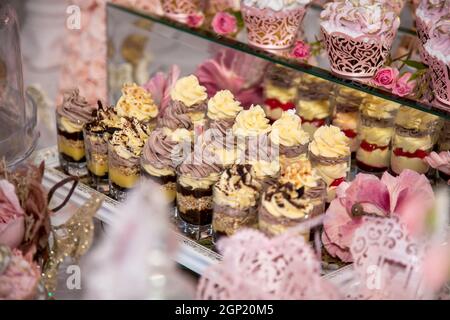 Délicieux desserts au bar à bonbons du mariage dans la zone du buffet : verres avec un dessert en couches avec chocolat, crème, noix, soufflé, crème fouettée. Banque D'Images