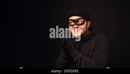 Portrait du voleur de funnu avec masque sur le dos sombre Banque D'Images