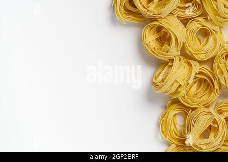 Pâtes italiennes de fettuccine isolées sur fond blanc. La tagliatelle brute niche isolée sur fond blanc. Pâtes italiennes traditionnelles Banque D'Images