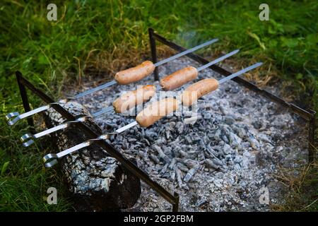 Saucisses frites sur brochettes. Soirées d'été près du feu, bon week-end Banque D'Images