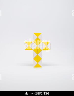 croix faite de triangles jaunes et blancs sur fond blanc. Banque D'Images