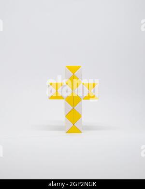 Croix faite de triangles jaunes et blancs sur fond blanc. Banque D'Images