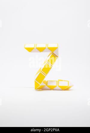 Lettre 'z' composée de triangles jaunes et blancs sur fond blanc. Banque D'Images