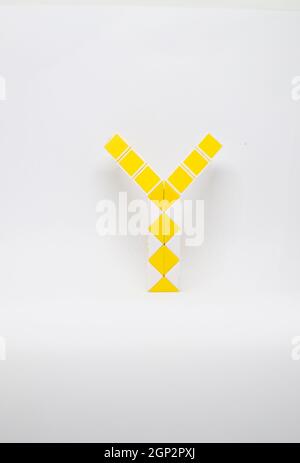 Lettre 'y' composée de triangles jaunes et blancs sur fond blanc. Banque D'Images