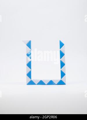 Lettre 'u' en bleu et triangles blancs sur fond blanc. Banque D'Images