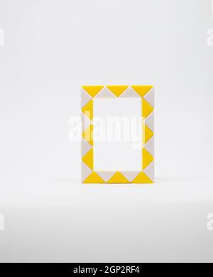 Lettre 'o' composée de triangles jaunes et blancs sur fond blanc. Banque D'Images