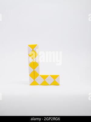 Lettre 'l' composée de triangles jaunes et blancs sur fond blanc. Banque D'Images