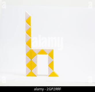 Lettre 'h' composée de triangles jaunes et blancs sur fond blanc. Banque D'Images