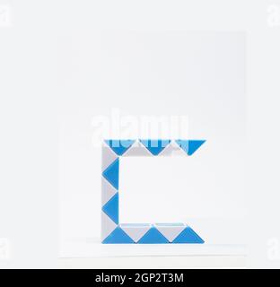 Lettre « c » composée de triangles bleus et blancs sur fond blanc. Banque D'Images