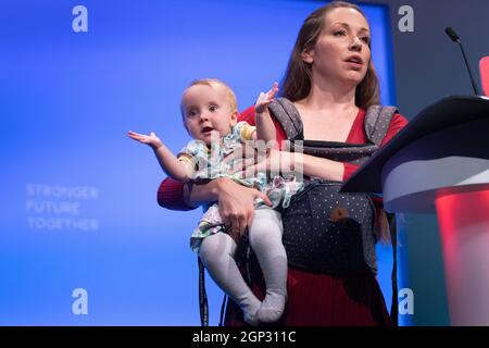 Catherine Atkinson tient son bébé Elena, âgée de 9 mois, alors qu'elle parle sur scène du soutien aux ex-militaires et aux femmes lors de la conférence du Parti travailliste à Brighton. Date de la photo: Mardi 28 septembre 2021. Banque D'Images