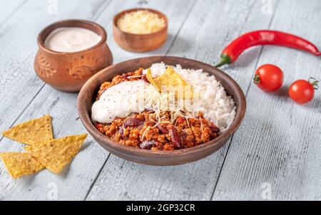 Chili con carne servi avec du riz, du fromage râpé et des chips de tortilla Banque D'Images