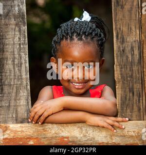 Gros plan sur un joli jeune africain pendu sur une clôture en bois à l'extérieur. Banque D'Images
