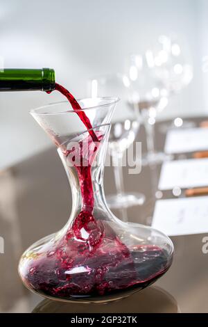 Macro gros plan du vin rouge versé dans le décanter lors de la dégustation de vin. Banque D'Images