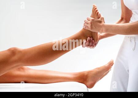 Close up of massage pied femelle physiothérapeute. Isolé sur fond clair. Banque D'Images