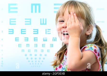 Relations sérieuses in Close up portrait of little girl testing vue.Vision graphique de test en arrière-plan. Banque D'Images