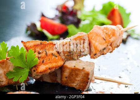 Macro gros plan de l'appétissant saumon grillé à l'omble et brochette de thon assaisonnée d'herbes. Banque D'Images