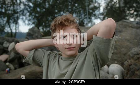 Jeune homme blond bien pensé aux yeux colorés, regardant à gauche et à droite à l'extérieur Banque D'Images