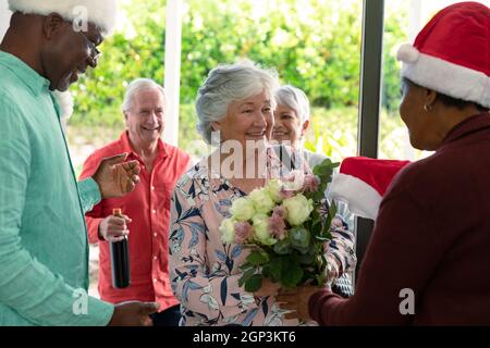 Groupe d'amis de sexe masculin et féminin se rencontrant à l'heure de noël Banque D'Images