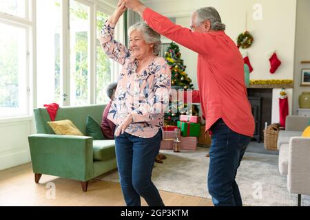 Joyeux couple de personnes âgées du caucase dansant dans le salon à l'heure de noël Banque D'Images