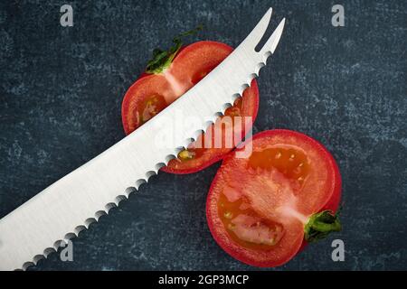 Coupe de tomates avec un couteau spécial à tomates, vue de dessus, gros plan Banque D'Images