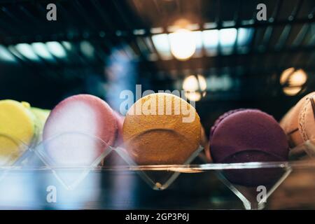 Des macarons multicolores sur une vitrine dans un café. Photo de haute qualité Banque D'Images