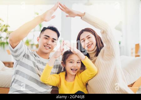 Happy asian famille formant le toit de la maison avec leurs mains à accueil Banque D'Images