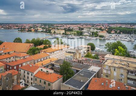 Vue sur les toits de tuiles orange et le paysage urbain de Zadar. Baie ou marina avec yachts amarrés et bateaux, Croatie Banque D'Images