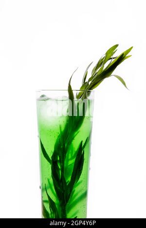 Cocktail vert, jus, limonade dans un verre transparent aux gouttes d'eau. Isolé sur un fond blanc. Décoration de cocktail : menthe, herbe d'estragon, Banque D'Images