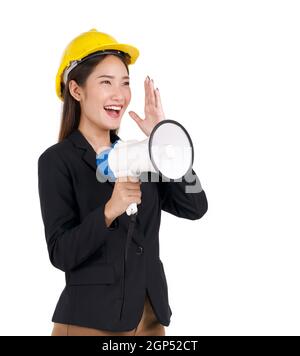 Une femme d'affaires portant un casque de construction jaune cria à un mégaphone. Portrait sur fond blanc avec lumière studio. Banque D'Images