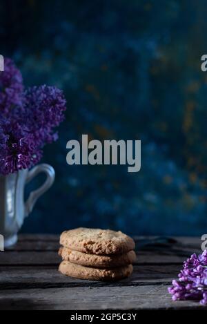 les biscuits continuent de vivre dans un style rustique sur un fond abstrait, avec des fleurs printanières. Banque D'Images