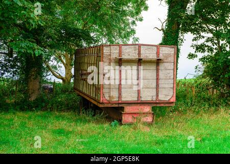 Très ancienne, à flancs de bois, remorque de ferme dans un champ Banque D'Images