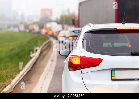 Voitures en attente dans le trafic bloqué avec feux de stop allumés. Vue arrière des véhicules stucked dans une voie sur la route en soirée. Automobiles sur Mot encombré Banque D'Images