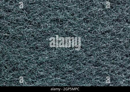Texture éponge noire. Gros plan du côté rugueux d'une éponge de cuisine pour le nettoyage des casseroles et poêles. Fond en éponge de cellulose. Macro. Banque D'Images