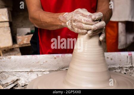 Homme faisant des articles en céramique sur la roue de potiers dans un Usine traditionnelle dans la ville de Ráquira située dans le département de Cundinamarca en Colombie Banque D'Images