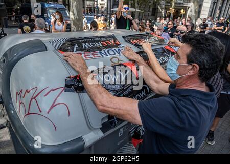 Barcelone, Espagne. 28 septembre 2021. On voit les chauffeurs de taxi reprendre le logo FreeNow arraché les portes de leurs véhicules dans un conteneur à ordures devant le siège de Free Now à Barcelone.les chauffeurs de taxi ont participé à une marche lente contre les compagnies de transport avec des conducteurs Uber et Free Now, Qu'ils accusent de concurrence déloyale selon les règlements de l'Institut métropolitain de taxi. Crédit : SOPA Images Limited/Alamy Live News Banque D'Images