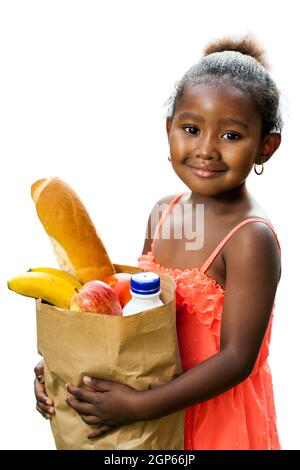 Gros plan portrait d'une jolie fille africaine en robe rouge tenant les articles d'épicerie essentiels dans un sac brun.isolé sur fond blanc. Banque D'Images