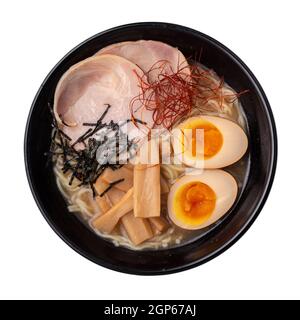La soupe asiatique de nouilles ramen avec œufs, porc et pousses de bambou dans un bol est isolée sur fond blanc, cuisine japonaise Banque D'Images
