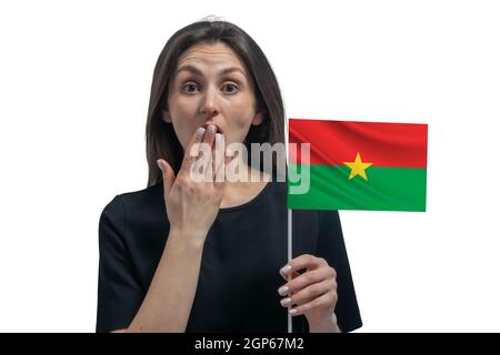 Bonne jeune femme blanche, drapeau du Burkina Faso et couvre sa bouche avec sa main isolée sur fond blanc. Banque D'Images