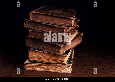 Pile de vieux livres de sorbellerie en cuir se liant sur fond sombre. Gros plan. Mise au point sélective Banque D'Images