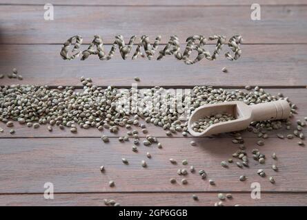 L'inscription cannabis à partir de graines de cannabis et de graines éparses sur une table en bois. Banque D'Images