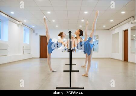 Deux jeunes ballerines répètent à la barre en classe. École de ballet, danseuses de chorégraphie, filles pratiquant la danse de grâce Banque D'Images