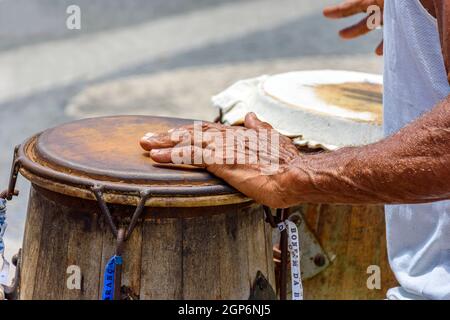 Musicien jouant un instrument brésilien traditionnel de percussion appelé atabaque lors d'un spectacle de capoeira dans les rues de Pelourinho à Salvador, Banque D'Images