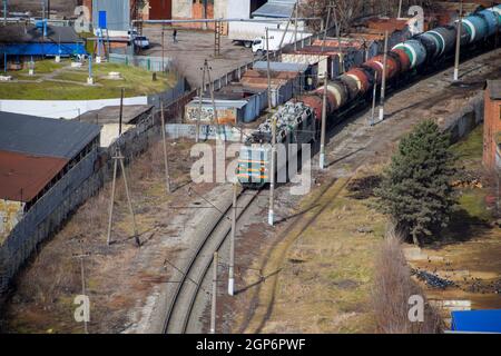 Krasnodar, Russie - Février 23, 2017 : train de marchandises qui transitent par les bâtiments de la ville Banque D'Images