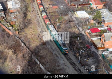 Krasnodar, Russie - Février 23, 2017 : train de marchandises qui transitent par les bâtiments de la ville Banque D'Images