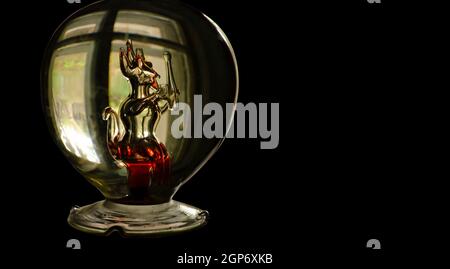 Une bouteille avec une figure de verre d'un diable avec des éléments rouges à l'intérieur. Concept du festival d'Halloween. Banque D'Images