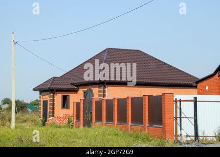 La chambre avec fenêtres en plastique et un toit de tôle ondulée. Roofing d'un profil en métal de forme ondulée sur la chambre avec des fenêtres en plastique. Banque D'Images