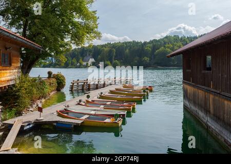 Location de bateaux à rames sur la jetée au lac de montagne Walchensee en Bavière, Allemagne, le jour ensoleillé avec la maison de bateau Banque D'Images