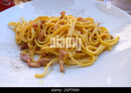 Des pâtes carbonara sont servies à l''extérieur dans un restaurant pizzeria de Lucques, en Italie Banque D'Images